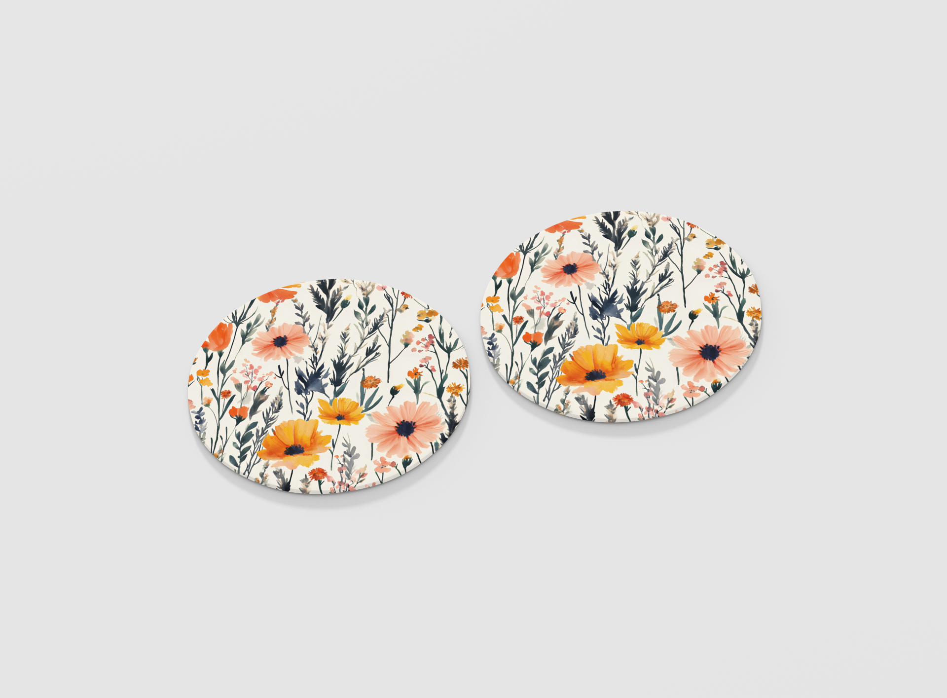 Pair of floral round coasters on a light gray background