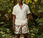 Off-white shorts with brown leaf print, elastic waistband, above-knee length