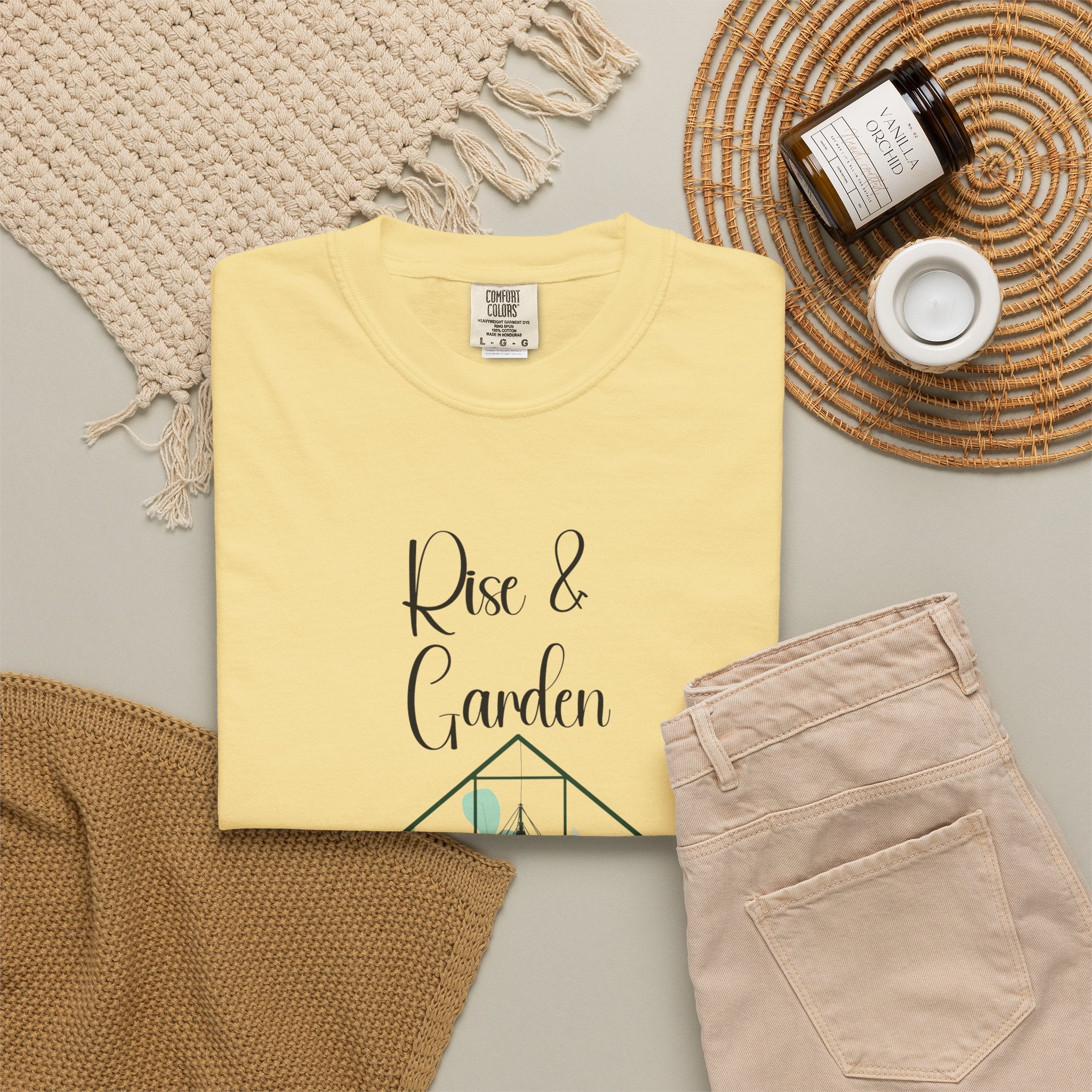 Yellow t-shirt with 'Rise & Garden' text on a neutral background