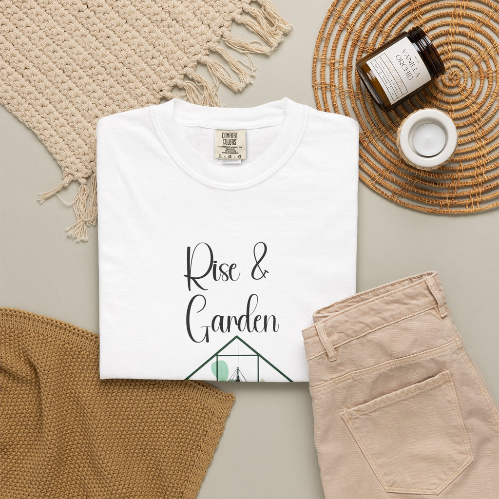 White t-shirt with 'Rocking My Bump' design on a neutral surface with pants and decor items.