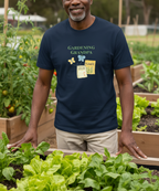 A smiling man wearing a navy blue graphic t-shirt that reads 'GARDENING GRANDPA' stands in a garden with raised beds and leafy greens.