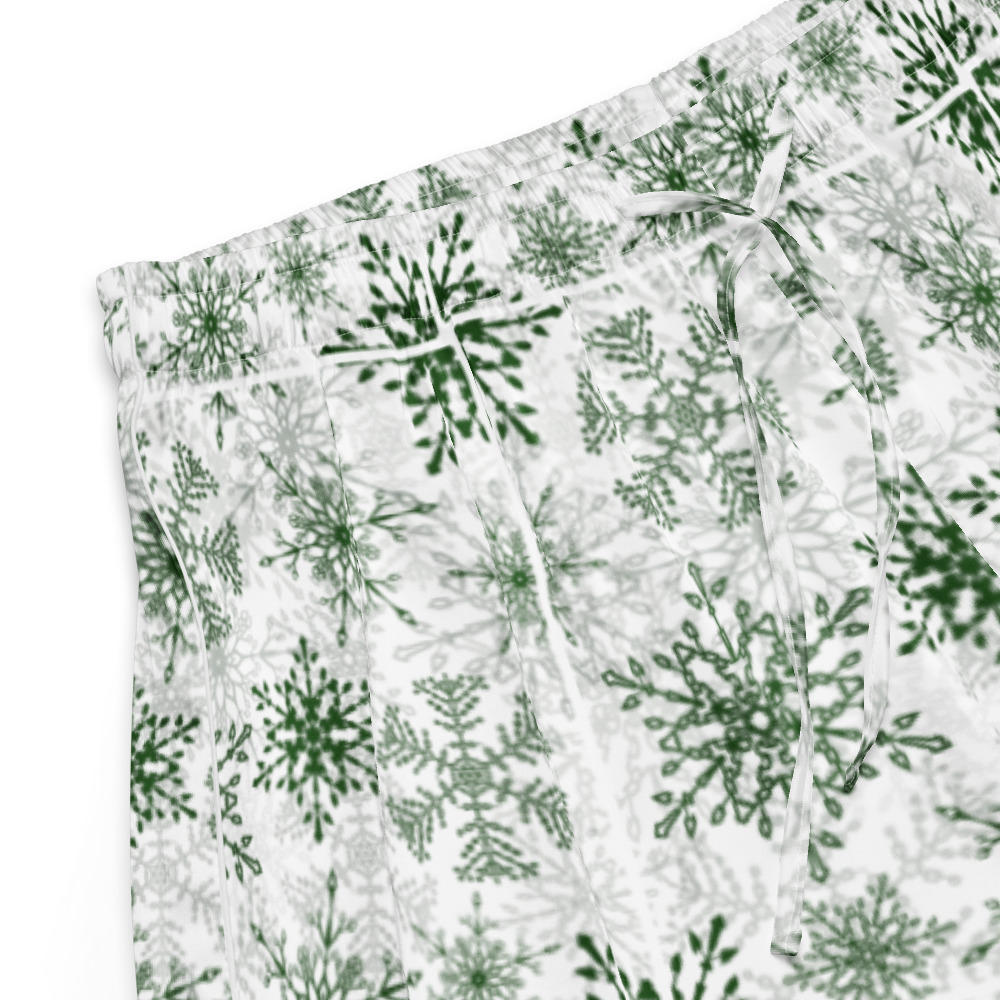 White fabric shorts with an all-over green snowflake pattern and a drawstring waist, shown on a plain white background.