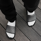 Black and white patterned sandals on a wooden floor