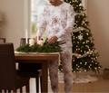 Indigenous man in pocket-free red snowflake pajamas making a Christmas centerpiece