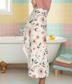 Person wearing a floral dress in a bathroom with colorful tiles and a bathtub.