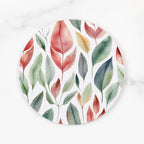Round white plate with colorful leaf pattern on a white background