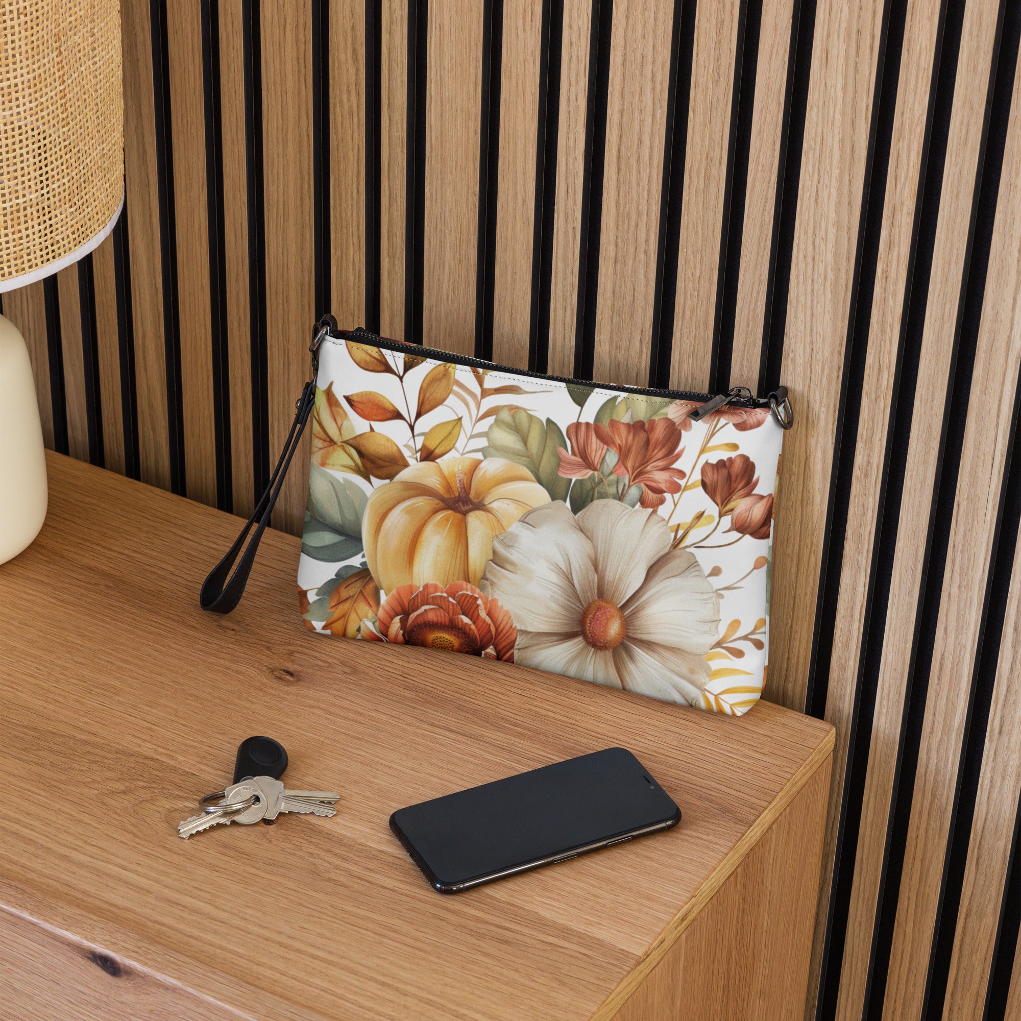 Floral pouch on a wooden surface with keys and a phone
