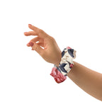 Hand wearing a floral scrunchie on a white background