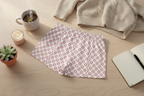 Floral-patterned headband on a wooden surface with a cup, candle, and notebook.