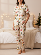 Person wearing Christmas-themed pajamas in a cozy bedroom with festive decorations.