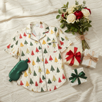 Christmas-themed pajama set with matching eye mask and small gift boxes on a textured surface.