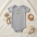 Gray New to the Patch flower baby onesie styled with baby accessories.