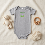 Gray New to the Patch flower baby onesie styled with baby accessories.
