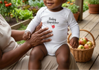 Baby boy in white with grandmother overlooking the garden
