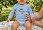 Baby girl in light blue beneath an apple tree