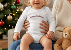 Baby girl with longer blond hair wearing the White Happy Holidays onesie