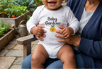 Baby in white overlooking a vegetable garden