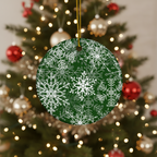 Green ornament with white snowflake pattern hanging on a decorated Christmas tree.