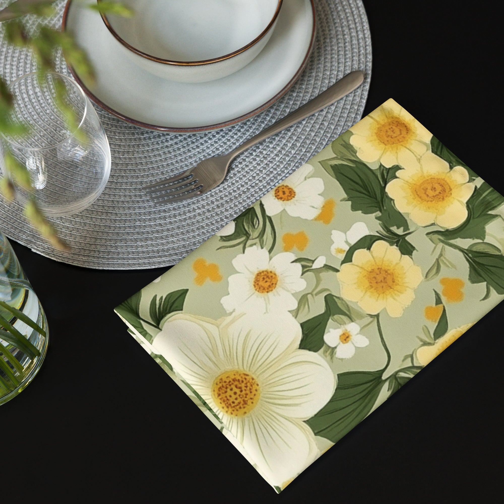 Floral-patterned napkin on a table setting with cutlery and plates.