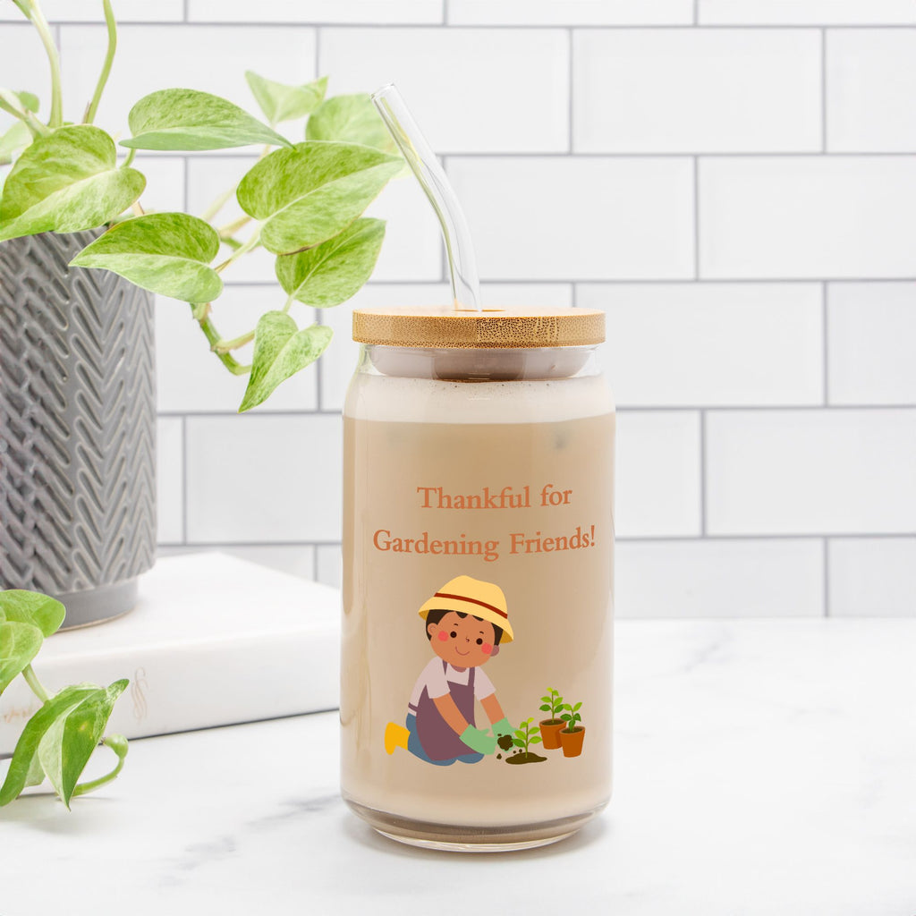 Jar with a cartoon character and text 'Thankful for Gardening Friends!' on a white surface with plants.
