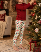 Girl in Leafy Dreams leggings hanging an ornament on a Christmas tree