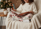 Middle Eastern child wearing Christmas present leggings in a warm indoor holiday reading nook