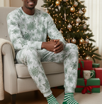 Black man wearing a matching green snowflake long sleeve crew neck pajama set in a Christmas living room
