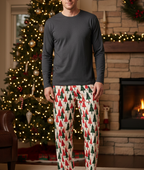 Unique blond white man wearing Christmas Tree men’s pajama pants with a charcoal shirt near a fireplace