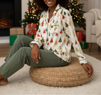 Black woman wearing the Spring Christmas women’s long sleeve pajama top with chest pocket and decorative piping in a Christmas living room
