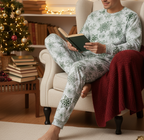 Middle Eastern man wearing a matching green snowflake long sleeve crew neck pajama set in a Christmas reading nook