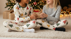 Two children with different skin tones wearing Spring Christmas leggings in a cozy indoor Christmas scene