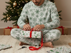 East Asian man wearing Green Snowflake pajamas while wrapping a Christmas gift