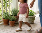 Toddler modeling the heather mauve Baby Bay Leaf onesie.