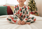 East Asian child wearing Christmas tree leggings with a matching printed top in a holiday bedroom