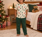 Child wearing a Christmas tree pajama top in a cozy festive bedroom