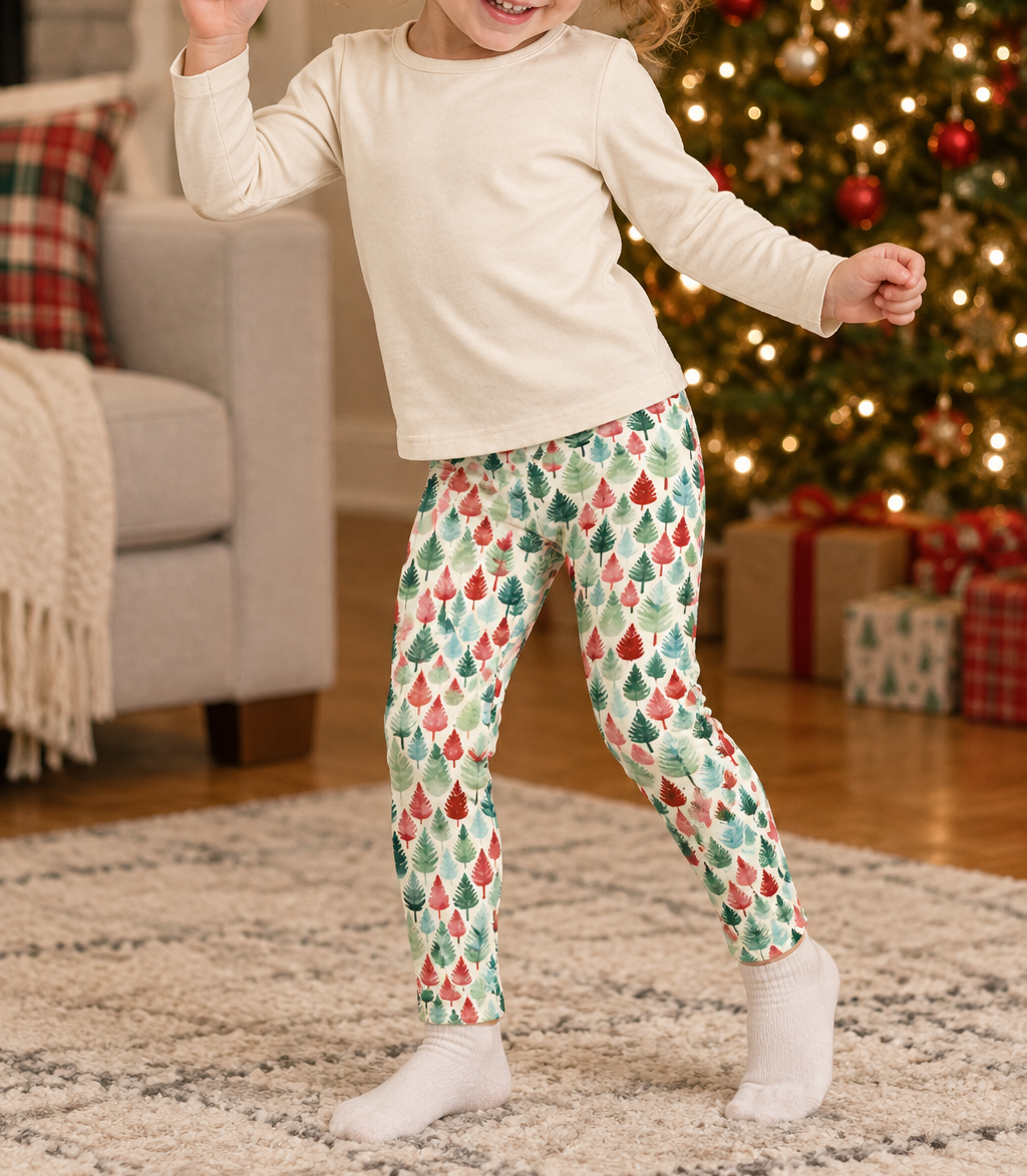 Toddler in Leafy Dreams leggings dancing by the lit Christmas tree
