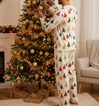 South Asian man wearing the complete Spring Christmas Tree matching pajama set while decorating a Christmas tree