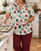 A woman baking holiday cookies wearing the ivory ornament-print short-sleeve pajama top and burgundy pajama pants.