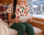 Child in Christmas Tree kids pajama top reading a letter in a cozy cabin