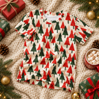 Christmas Tree kids pajama top with red and green tree print on a cozy knit blanket with gifts and cocoa