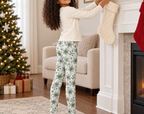 Child wearing Green Snowflake kids leggings while hanging a holiday stocking