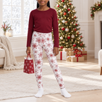 Child wearing Red Snowflake kid pajama leggings by a festive window