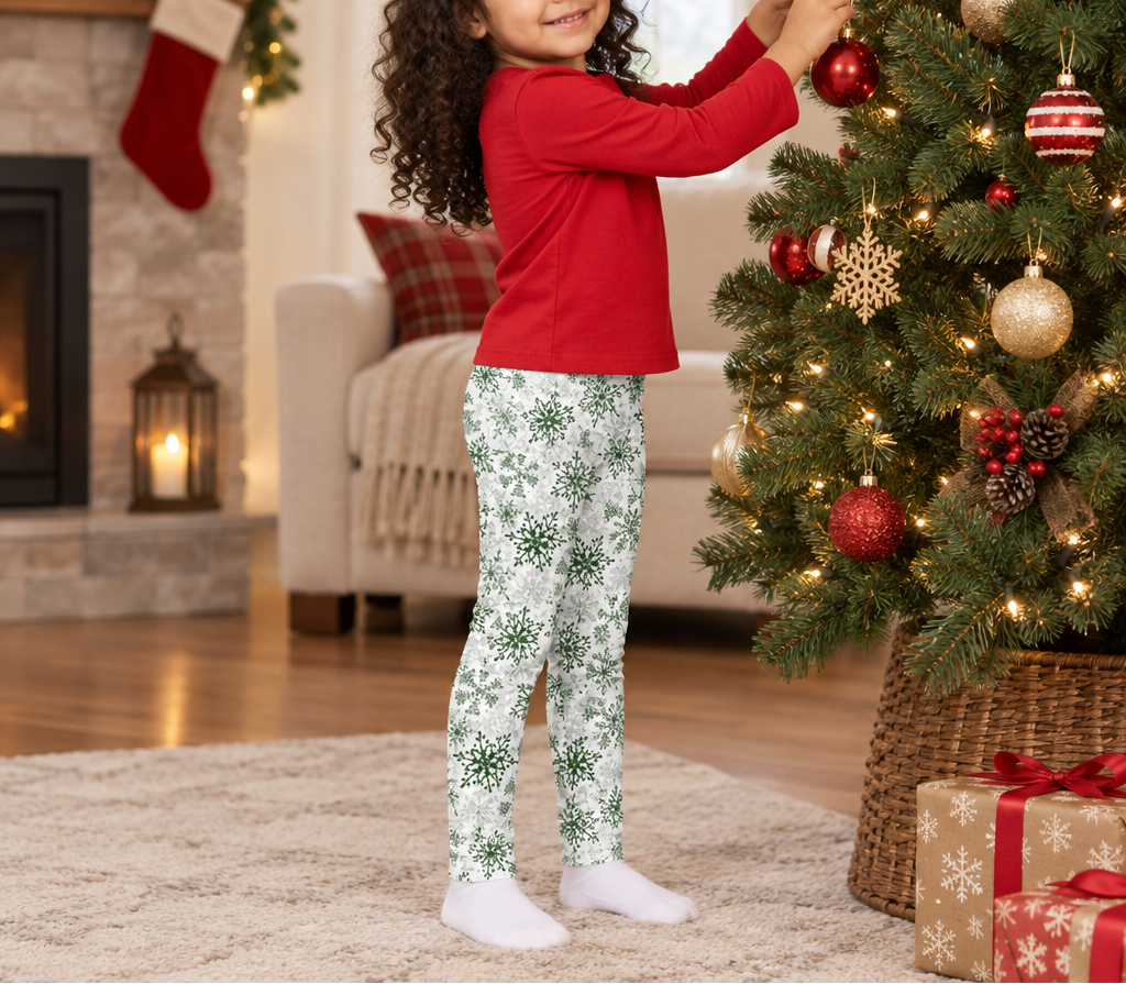 Child wearing Green Snowflake kids leggings while decorating a Christmas tree