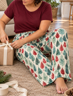 Leafy Dreams women's pajama pants tying a ribbon around a gift