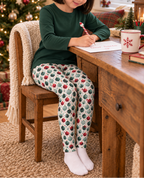 Child wearing Holiday ornament leggings writing a letter to Santa