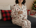 East Asian woman wearing the Christmas Present women’s long sleeve pajama top in a festive bedroom