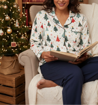 Middle Eastern woman wearing the Blue Christmas women’s long sleeve pajama top in a Christmas reading nook