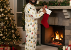 Man with locs wearing Spring Christmas pajamas while hanging a stocking