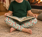Boy in Leafy Dreams leggings reading by the fireplace