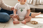Baby wearing the white Baby Bay Leaf onesie.